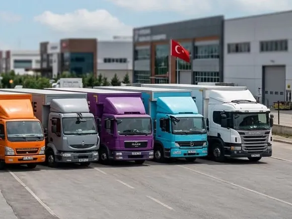 Türk bayrağı dalgalanan tesis önünde sıralanmış Güven Nakliye kamyonları
